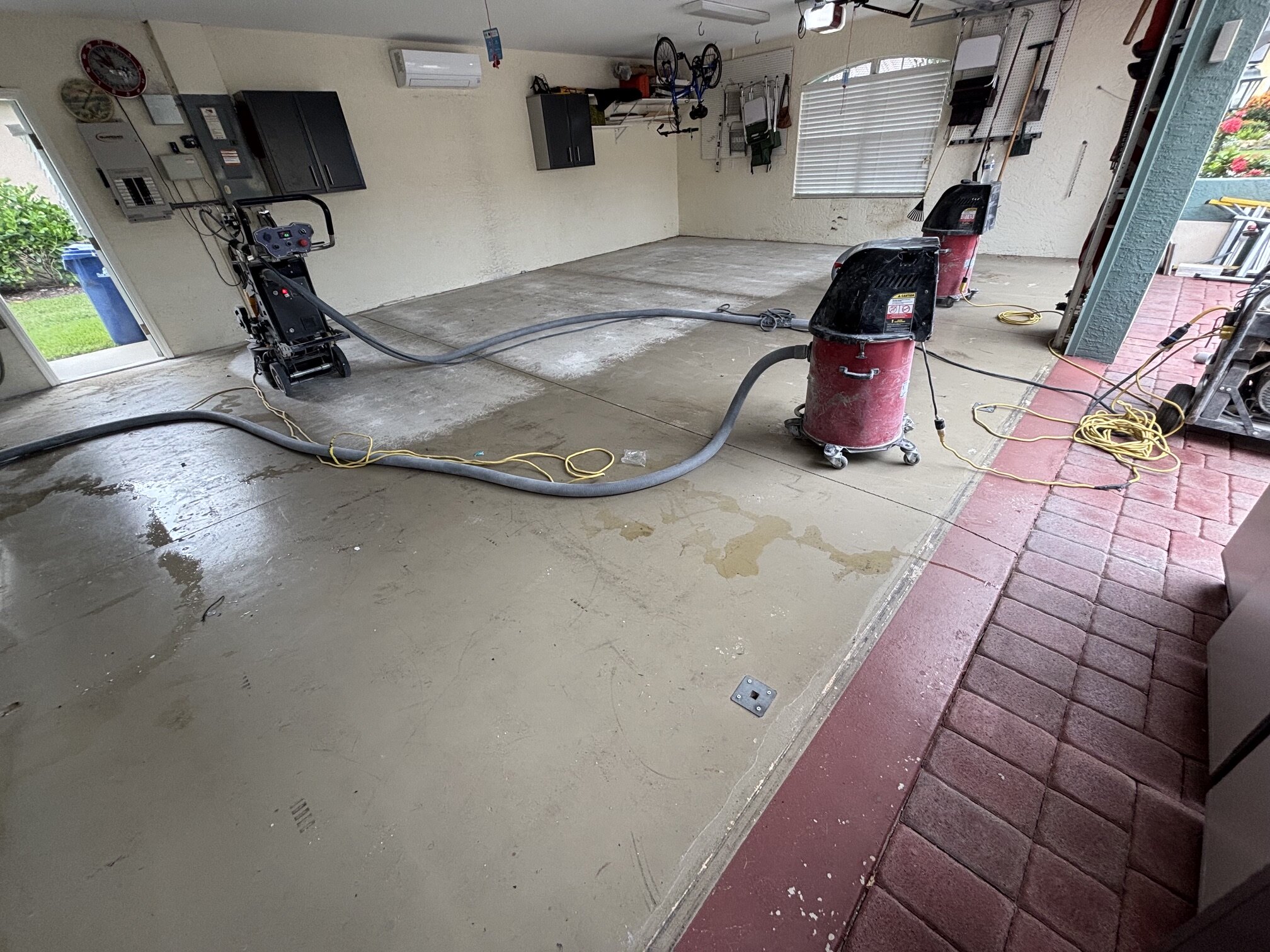 Sarasota garage floor during preparation, with floor equipment and dust collection visible