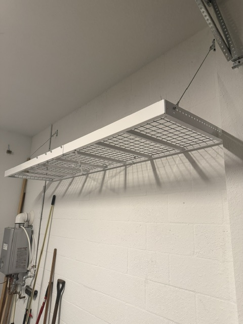 Garage overhead storage racks using ceiling space above the parking area
