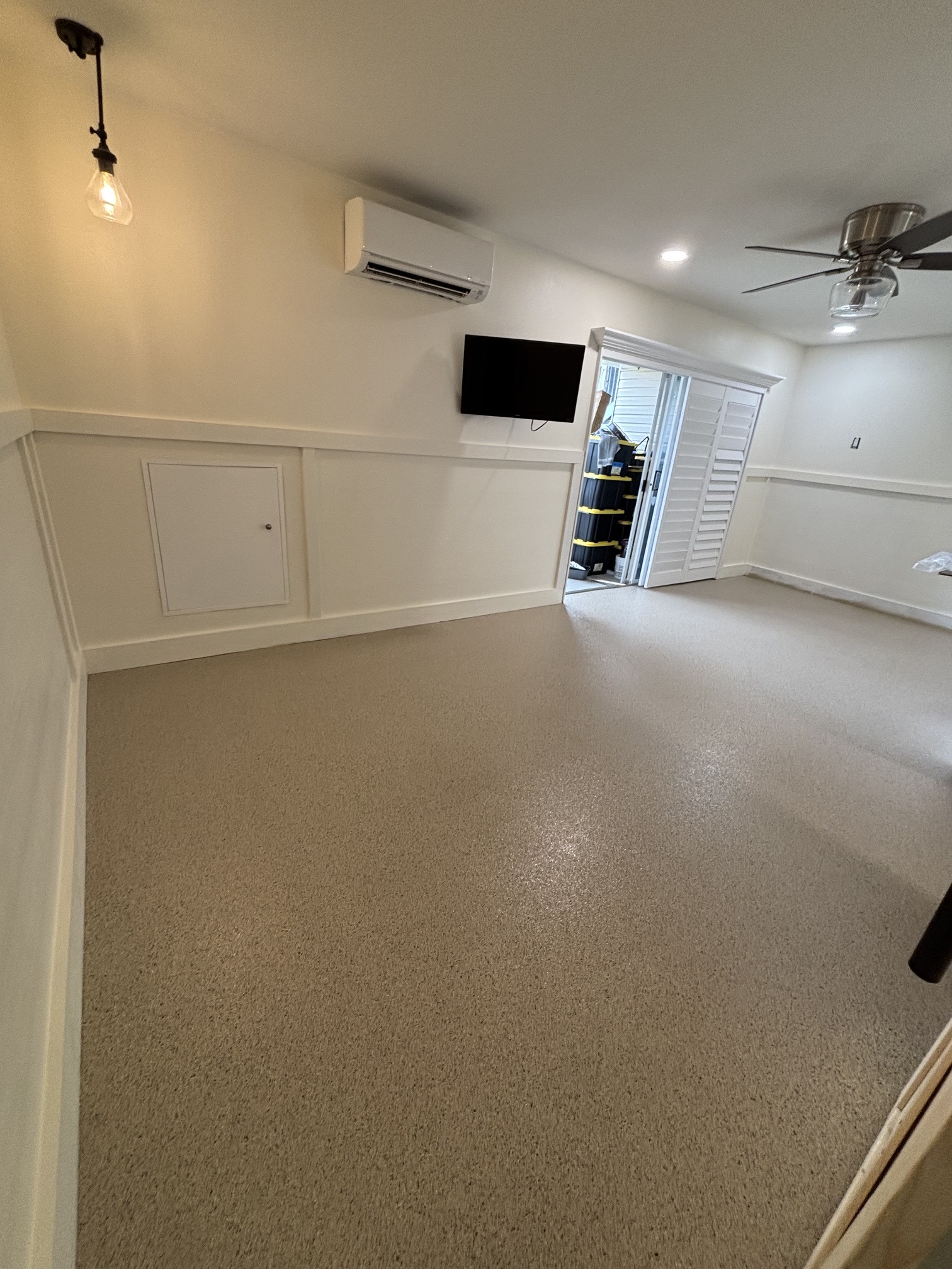 Bright finished garage or interior room with a decorative flake floor coating