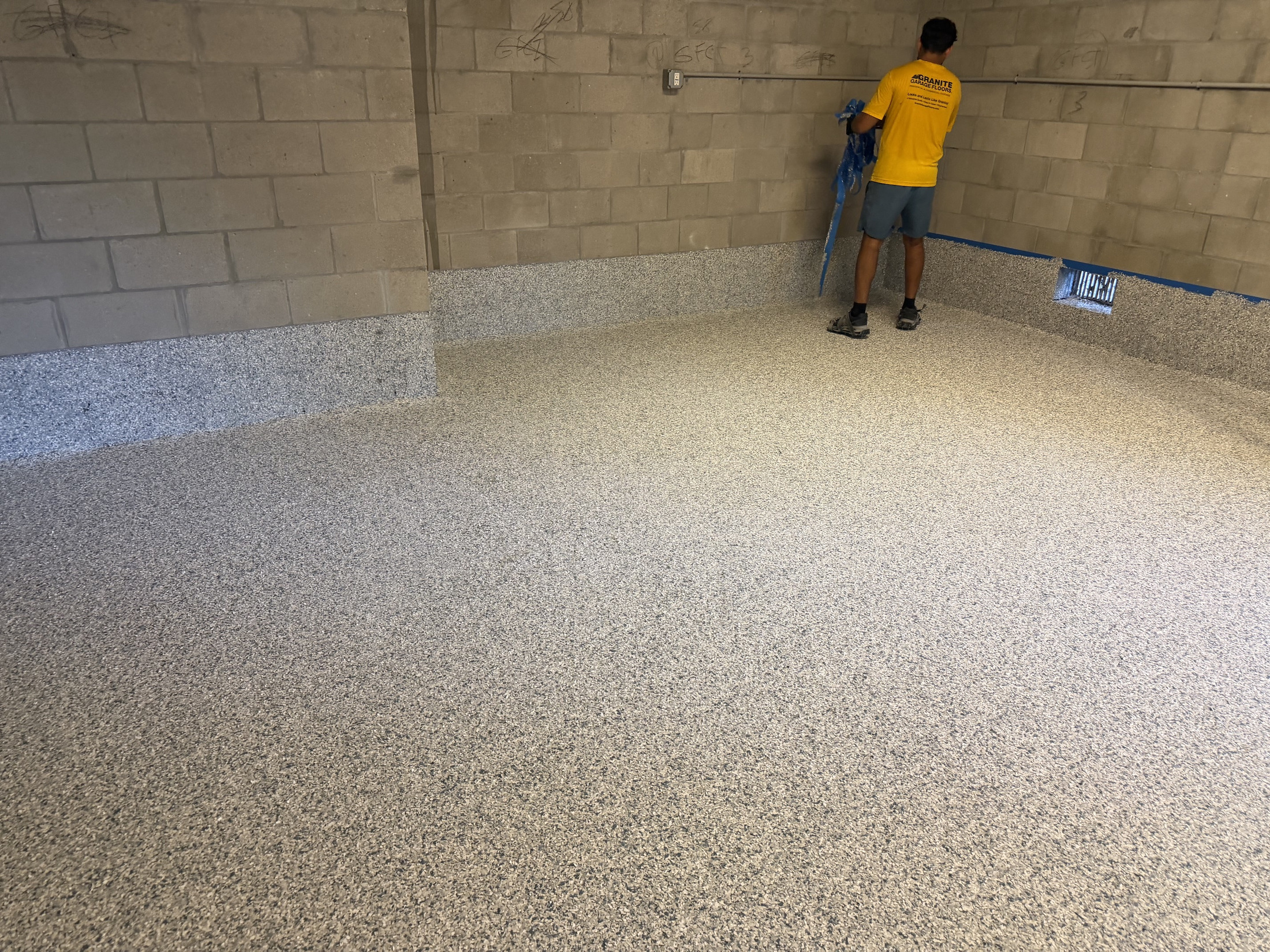 Decorative coating installation in progress across a residential concrete floor