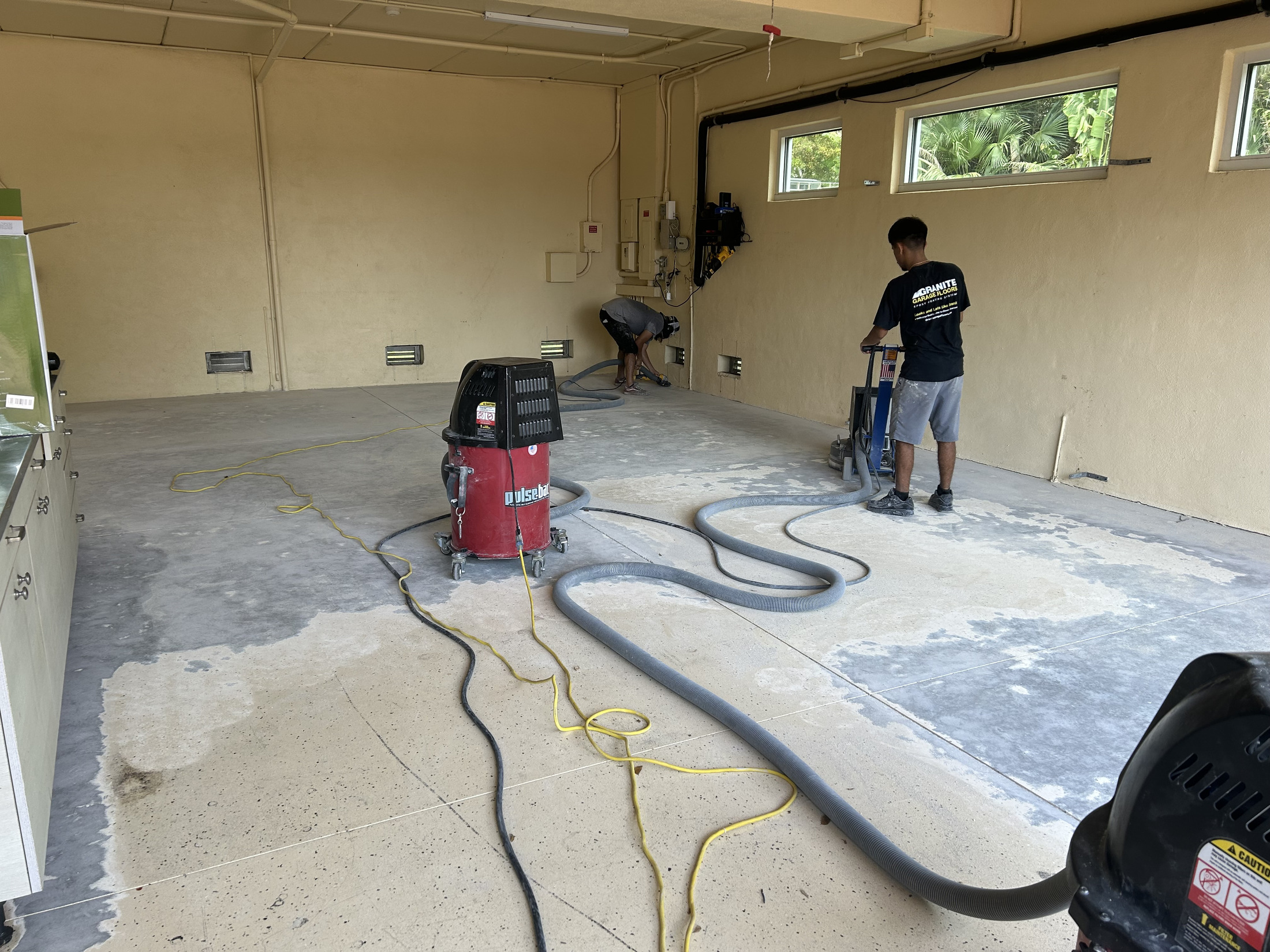 Garage concrete being mechanically prepared with professional floor equipment