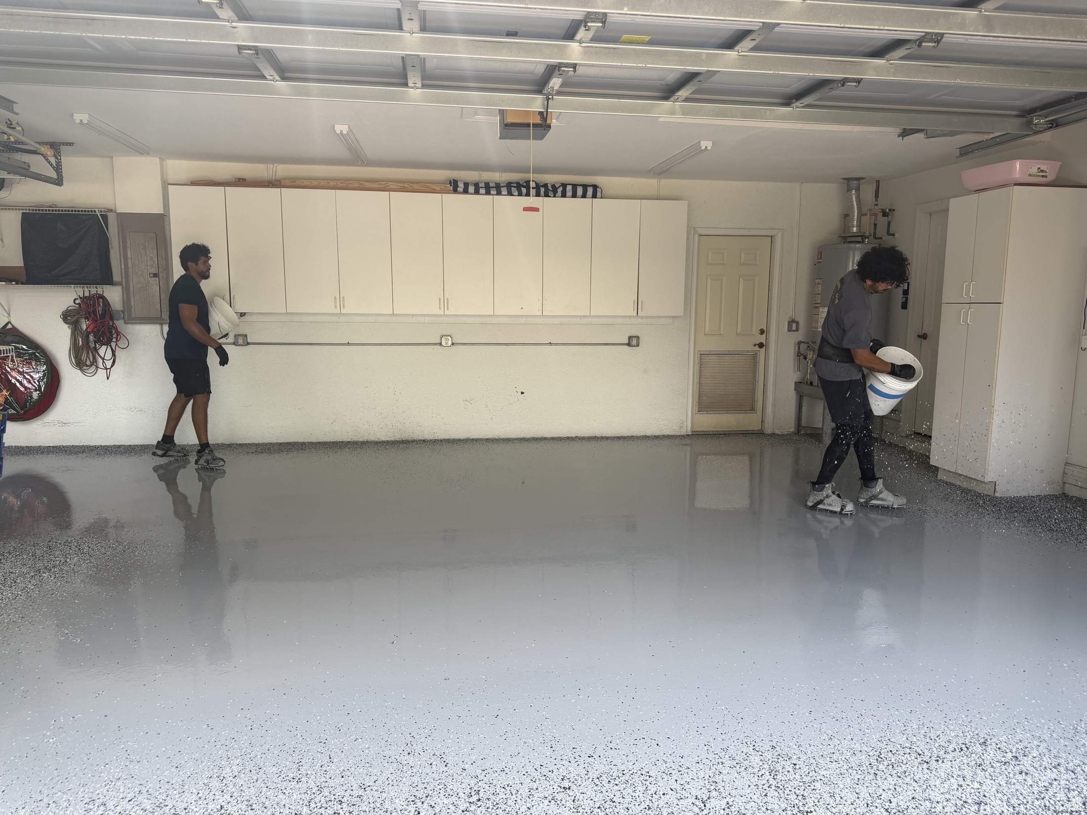 Glossy coating layer being installed across a prepared concrete floor