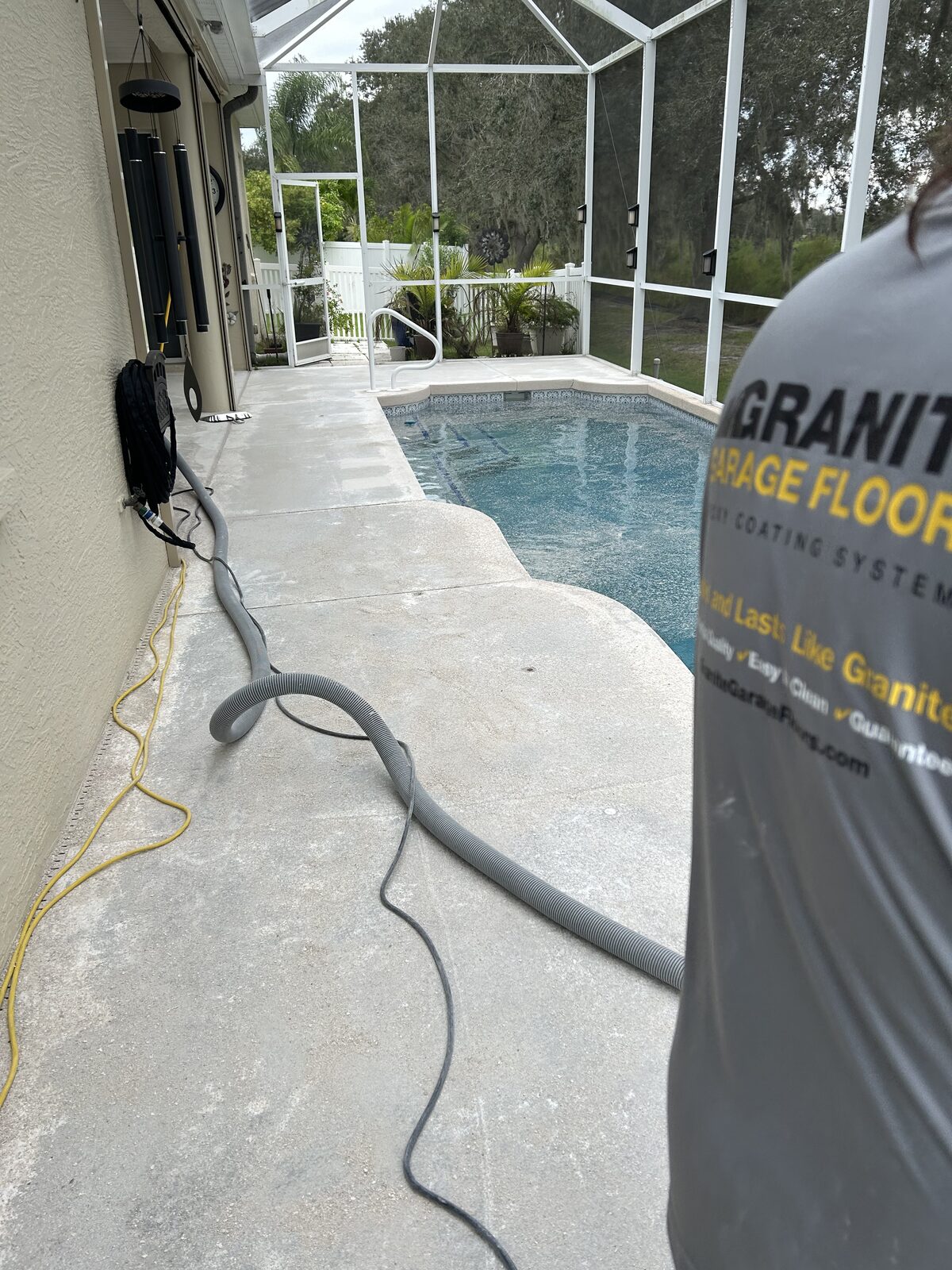 Pool deck concrete being mechanically prepared before coating
