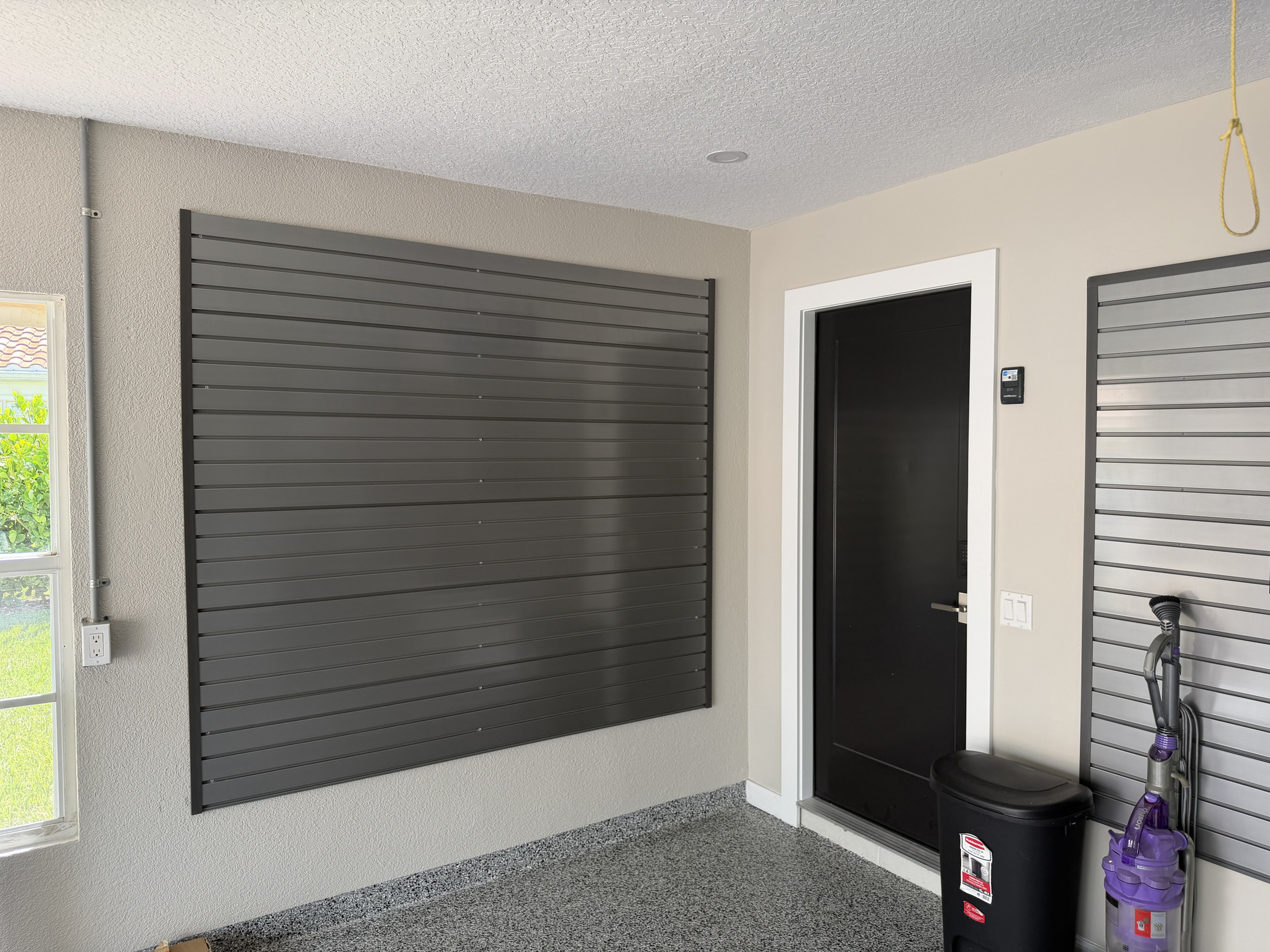 Garage storage wall with slatwall panels and organized accessories