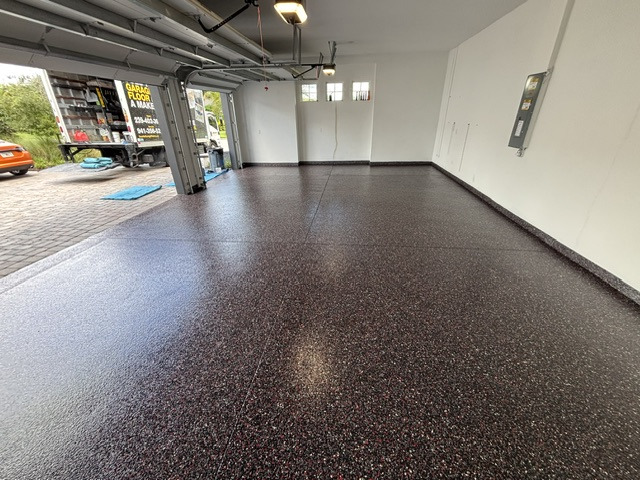Finished garage with a bold red and black decorative flake floor