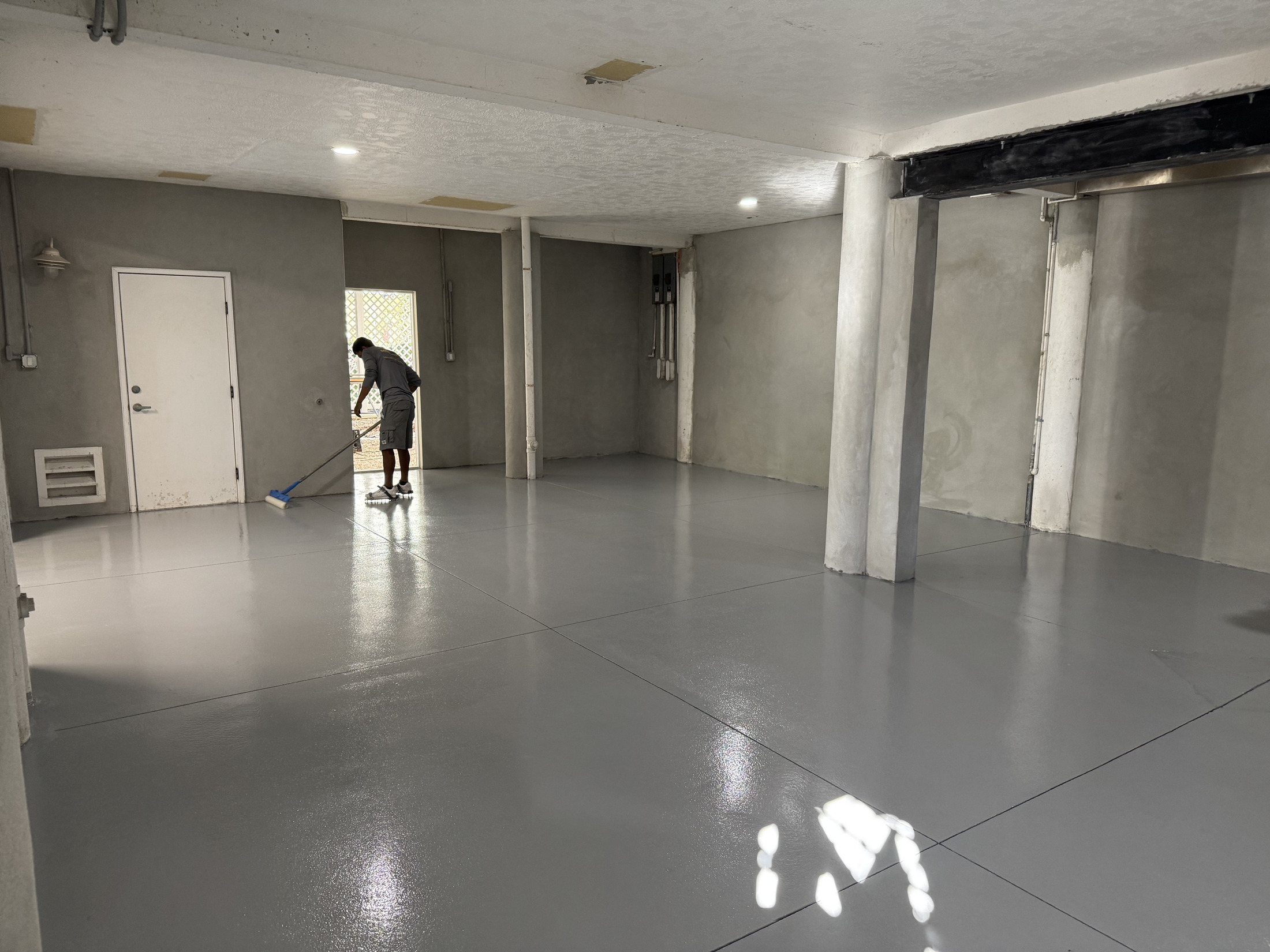 Existing garage coating being mechanically removed during preparation