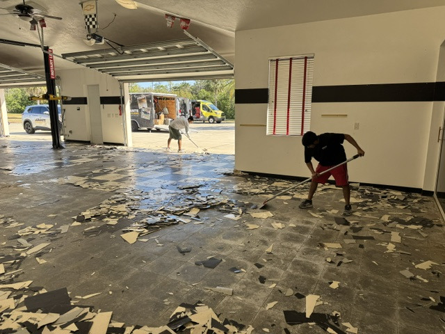 Concrete preparation underway in a garage with vehicle lifts
