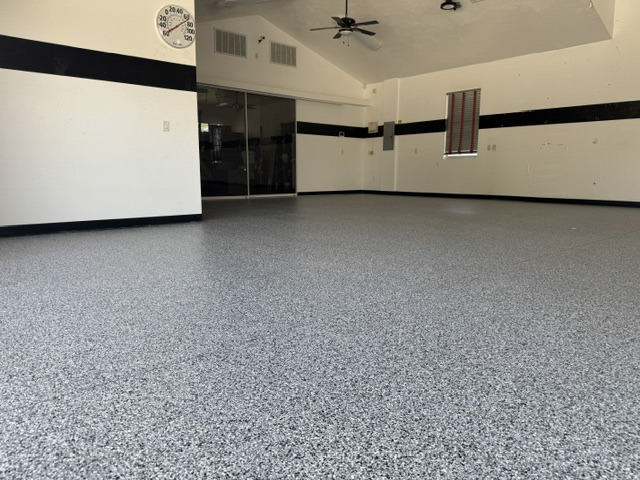 Completed gray decorative garage floor surrounding vehicle lifts