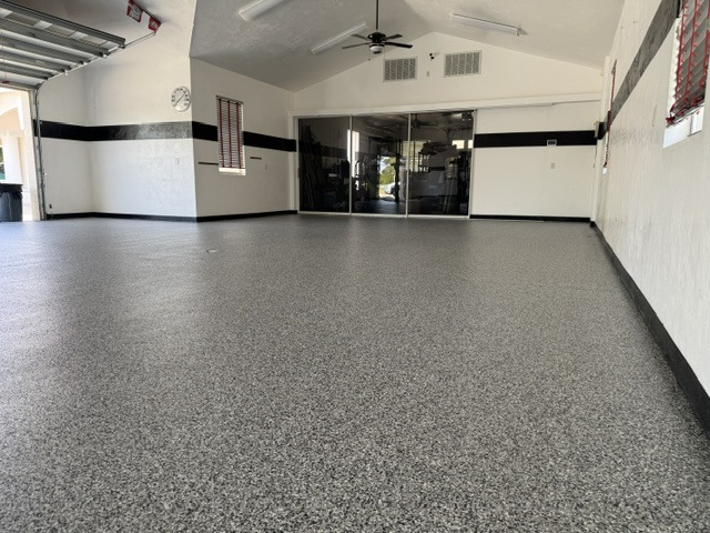 Finished gray decorative floor in a garage with vehicle lift equipment