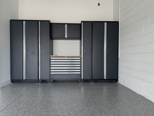 Garage cabinet and workbench area paired with a finished floor